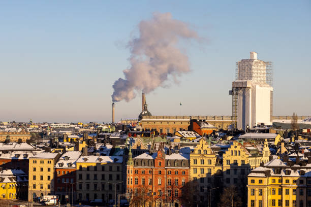 panorama of stockholm city with colorful houses and chimney with smoke on a sunny winter day - stockholm sweden sea winter imagens e fotografias de stock