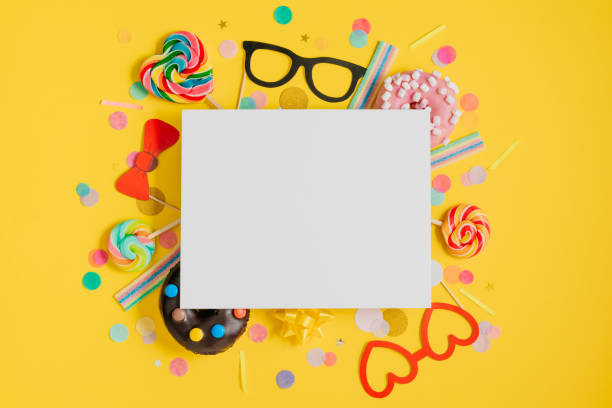 istock Paper glasses and sweets with multicolored confetti on yellow background 1358191166