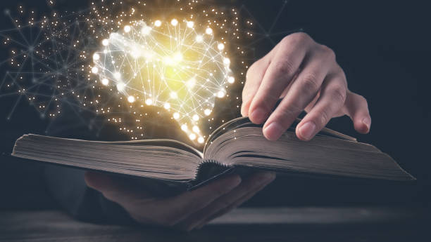 Man holding book with a human glowing brain. stock photo