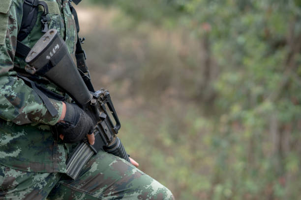 istock close up soldiers with gun. 1358192113