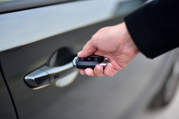 istock Female hand presses on the remote control car alarm system 1358192181