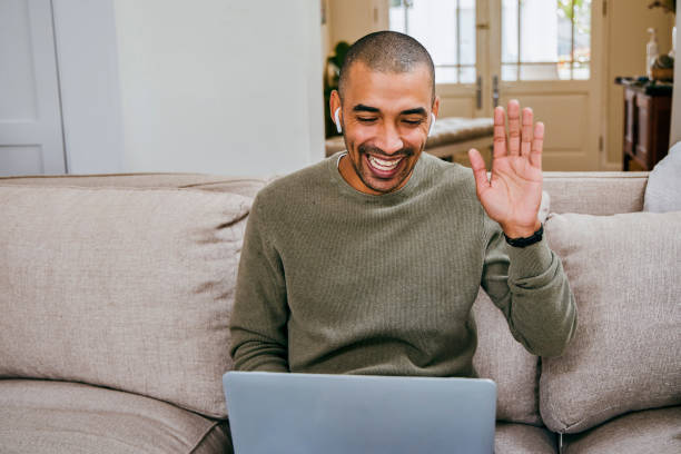 istock Shot of a young man using his laptop to make a video call while working from home 1358192348