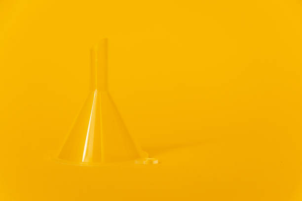 Transparent plastic funnel on yellow background with place for text