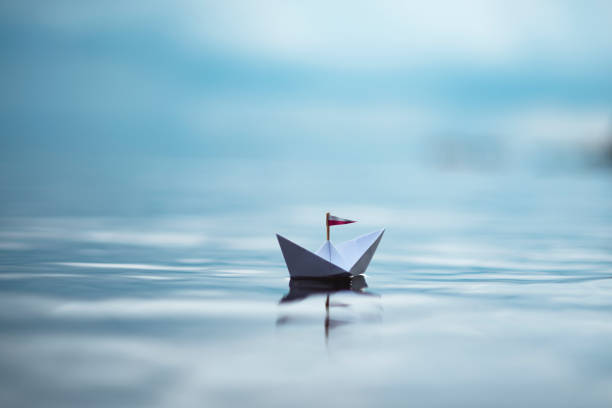 istock Paper Boat sailing on still Water 1358194612