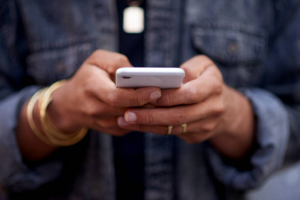 istock Cropped shot of an unrecognizable and stylish young man texting while standing outside against a grey wall 1358196528