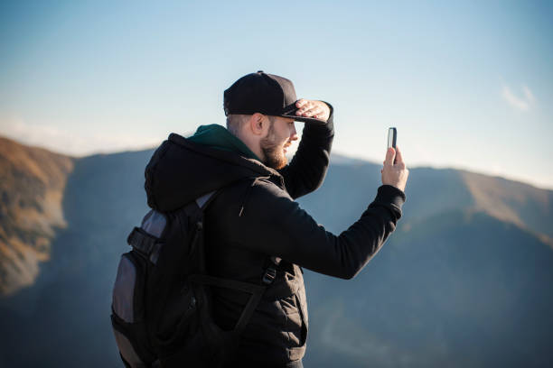 istock Tourist takes on smartphone mountain scenery 1358197809