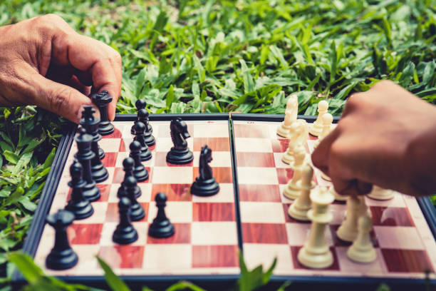 istock hand of moves chess on game chess board in park. 1358199072