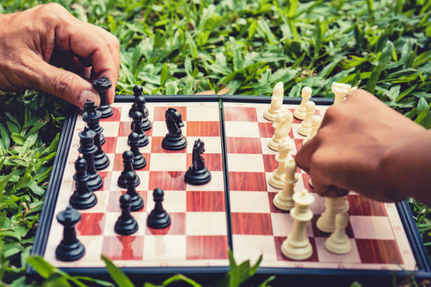 istock hand of moves chess on game chess board in park. 1358199073