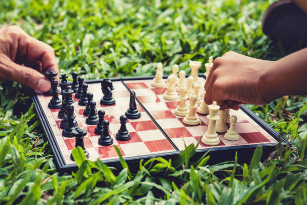 istock hand of moves chess on game chess board in park. 1358199101