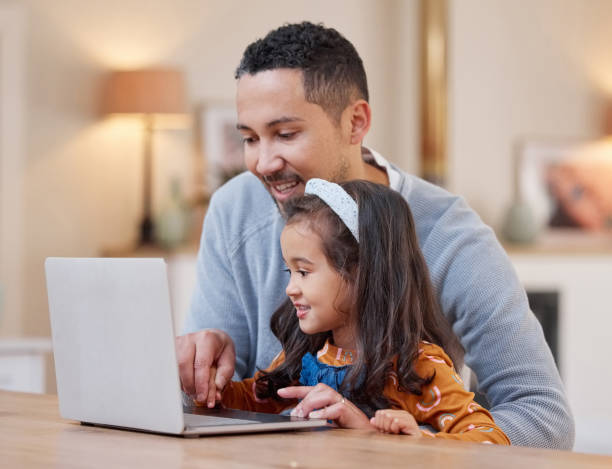 istock Shot of a father helping his daughter with her school work using a laptop 1358199834