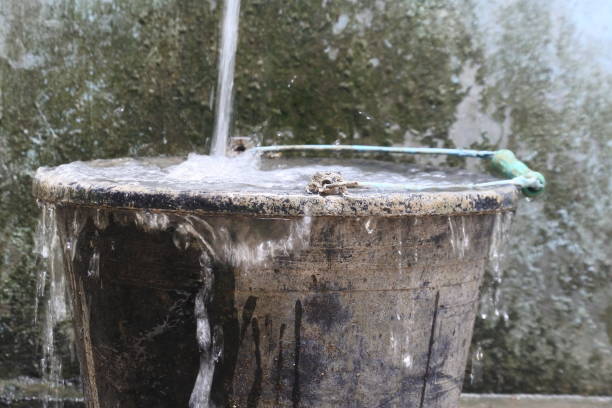istock water spills from black bucket. full does not fit anymore. overload 1358200959