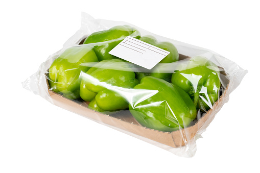 Brown open corrugated cardboard moving box, filled with green styrofoam pellets or packing peanuts falling out on white background. Contains clipping path.