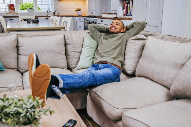 istock Shot of a handsome young man relaxing on his couch 1358207605