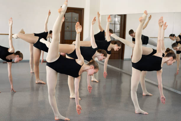 istock Young ballerinas do complex exercises in ballet school 1358209078