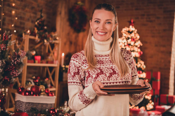 istock Photo of pretty adorable young lady dressed print pullover preparing christmas dinner smiling indoors room home house 1358209458