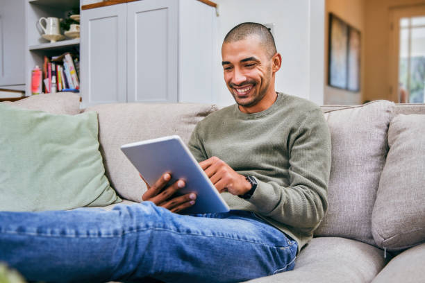 istock Shot of a young man using his digital tablet at home 1358211527