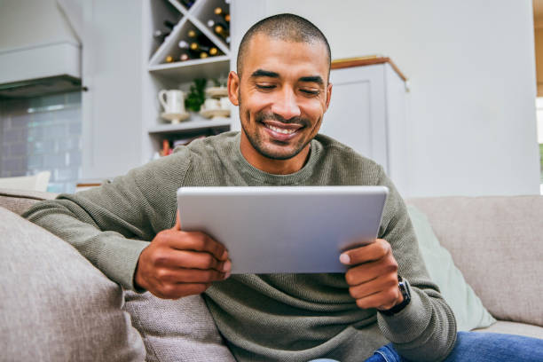 istock Shot of a young man using his digital tablet at home 1358211811