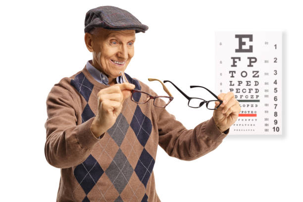 istock Elderly man holding glasses in front of vision exam 1358212270