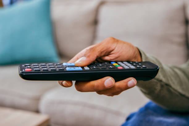 istock Shot of a man holding a remote control while watching TV 1358212778