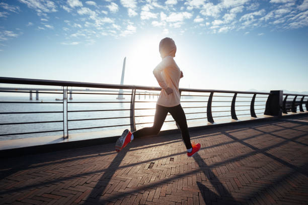 istock Fitness woman runner running on seaside bridge 1358214829