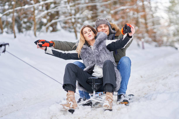 istock Couple having fun with sledge on snow in winter 1358216894