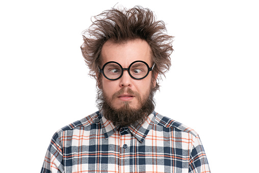 Crazy Bearded Man with funny Haircut in Eyeglasses making Grimace. Silly Guy in plaid shirt, isolated on white background. Emotions and signs concept