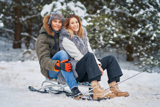 istock Couple having fun with sledge on snow in winter 1358217980