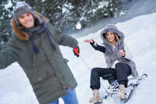 istock Couple having fun with sledge on snow in winter 1358218212