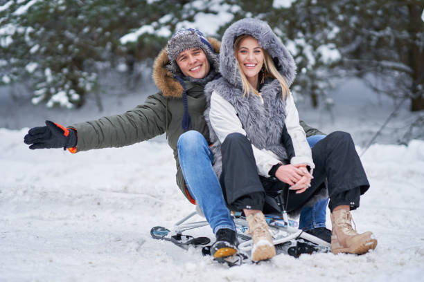 istock Couple having fun with sledge on snow in winter 1358218418