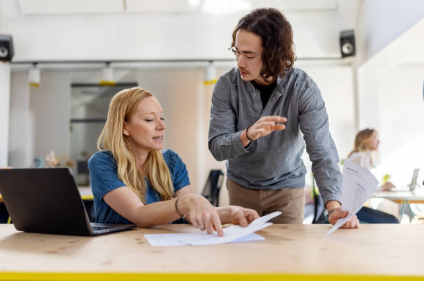 istock Two businesspeople having a discussion over some documents at office 1358219304