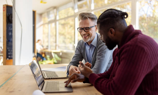 istock Business professionals discussing work in startup office 1358219359