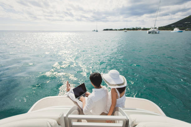 Two business people working with laptop on a sailing boat - sailing trip. Two business people working with laptop on a sailing boat - sailing trip. mauritius stock pictures, royalty-free photos & images