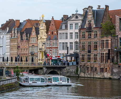 view of the River Leie and historic buildings on the Korenlei in the center of Gent. Gent has a historic city centre and is a hugely popular tourist destination in East Flanders.