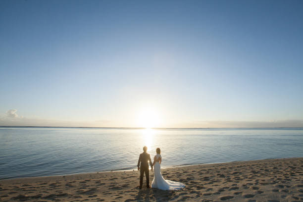 istock bride and groom meet the sunset on the beach 1358219840