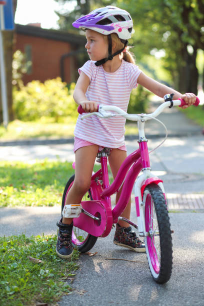 istock Little girl on bicycle in park 1358219869