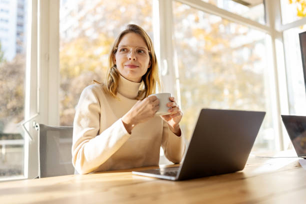 istock Thoughtful woman entrepreneur having coffee at office 1358221155
