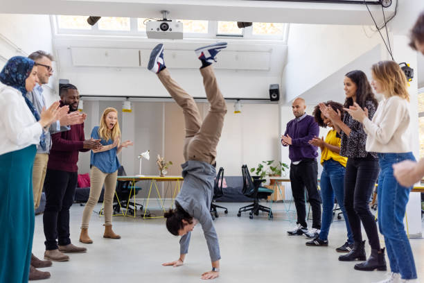 le personnel de bureau célèbre un succès au bureau avec un handstand sauvage - équilibre sur les mains photos et images de collection