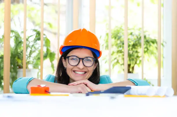 Photo of Photo of smiling female engineer wearing orange helmet.
