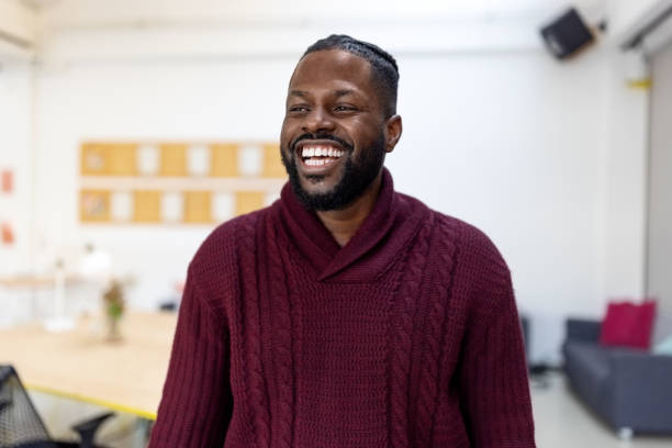 Cheerful African young man standing at startup office