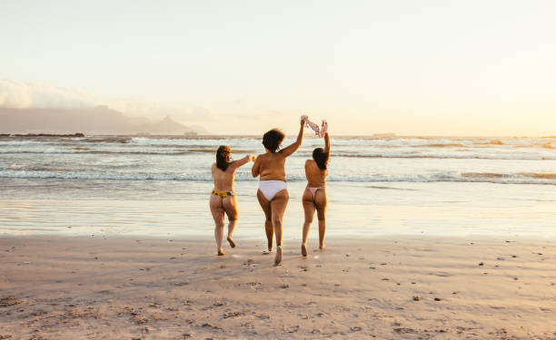 женщины наслаждаются летом в своих естественных телах - shirtless beach women bikini стоковые фото и изображения