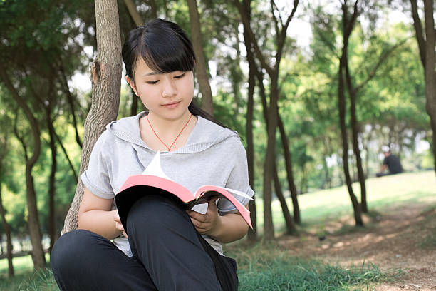 istock girl reading in the nature 135822350