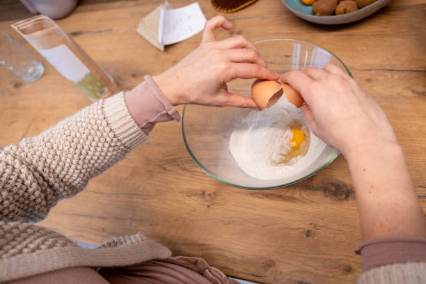 istock Hands close up of a woman cracking an egg in the home kitchen 1358224978