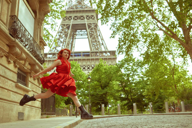 So much happiness in Paris Dynamic caption with redhead woman while jumping on the streets facing the camera air jump stock pictures, royalty-free photos & images
