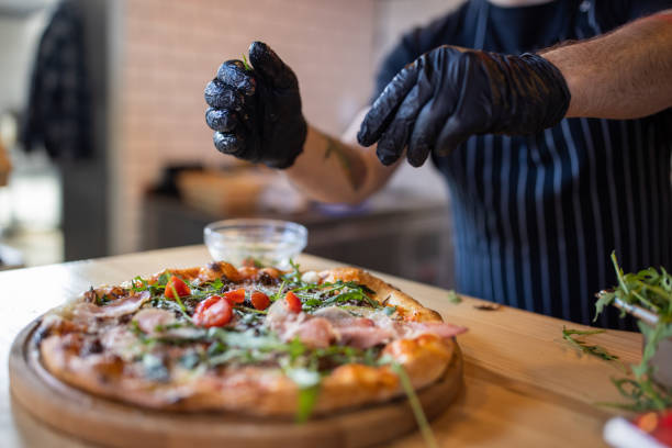 istock Unrecognizable chef adding the dry cherry tomato on the pizza 1358228918