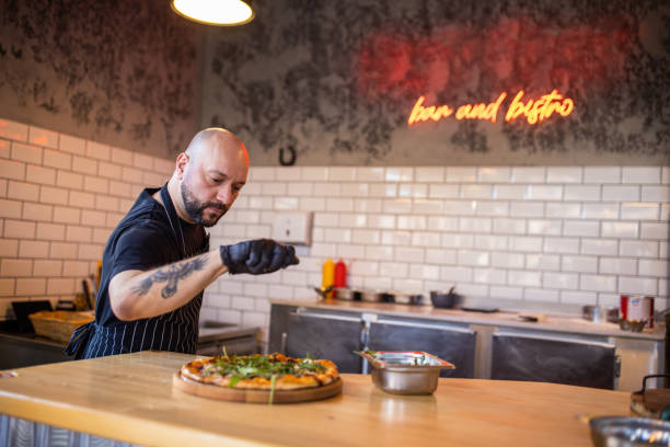 istock Dedicated Caucasian pizza maser adding parmesan cheese on the pizza 1358229206