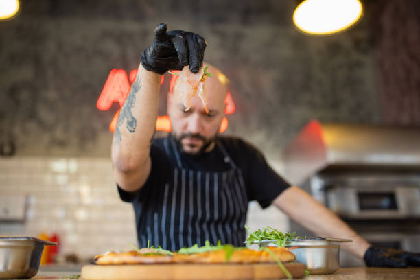 istock For final touch, Caucasian pizza chef adding the slice of prosciutto on pizza 1358229956