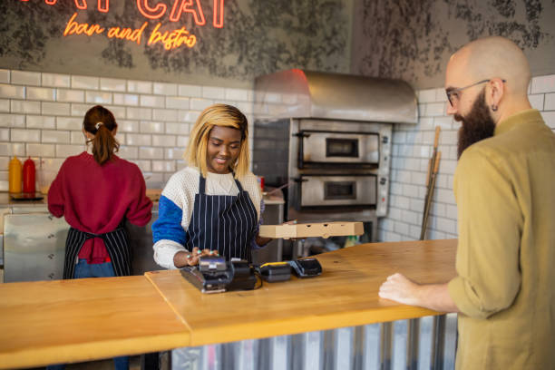 At the modern pizzeria, customer picks up his pizza order