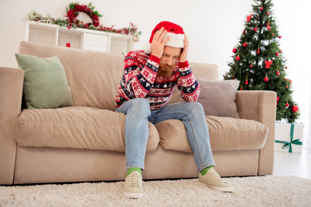 istock Full size photo of stressed depressed unhappy guy hate new year christmas have problem trouble sit sofa thinking 1358231503