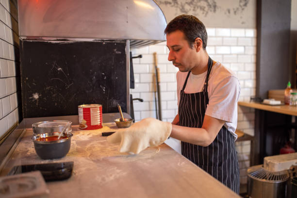 istock In the kitchen, Caucasian chef knead the dough for pizza 1358231878