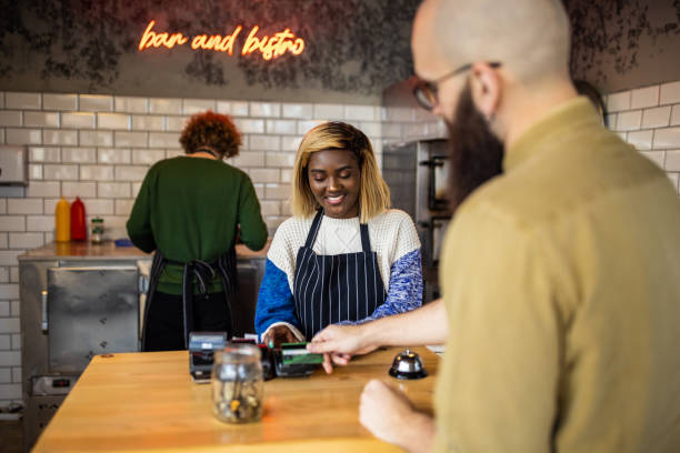 istock Caucasian customer using contactless payment to pay for purchase at fast food restaurant 1358232096